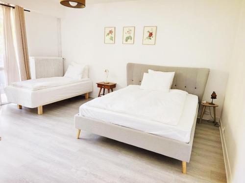 a white bedroom with a bed and a chair at Cozy Garden Rooms in Chevilly-Larue