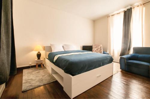 a bedroom with a bed and a blue couch at Maison de ville cosy Saumur avec Cour A 5 min à pied centre in Saumur