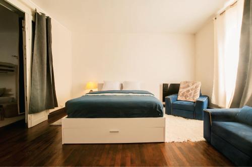a bedroom with a bed and a blue couch at Maison de ville cosy Saumur avec Cour A 5 min à pied centre in Saumur