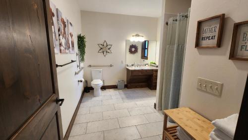 a bathroom with a toilet and a sink and a mirror at Parkside Cabins in West Yellowstone