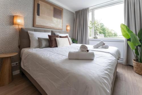 a bedroom with a large white bed with a teddy bear on it at University Tilburg Affordable Room walk in Nature in Tilburg