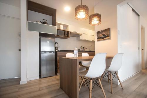 a kitchen with a wooden table and white chairs at Enlightening 1BR in Miraflores in Lima