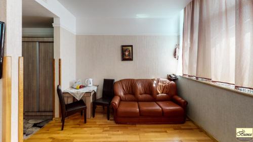 a living room with a leather couch and a table at Pensiunea Bianca in Botoşani