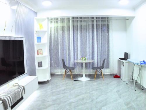 a living room with a tv and a table and chairs at AlTyn Stay in Male City