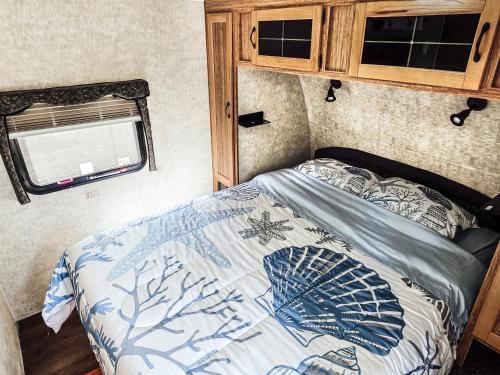 a bed in a small room with a window at Nicevilles' Hidden Backyard Camper in Niceville