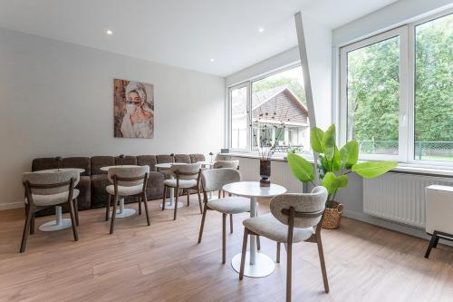 ein Esszimmer mit Stühlen, einem Tisch und Fenstern in der Unterkunft University Tilburg Affordable Room Walk In Nature in Tilburg