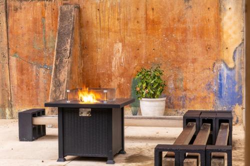 a table with a fire on it next to two benches at Historic Downtown Studio, Steps to Bathhouse Row, Room # 203 in Hot Springs