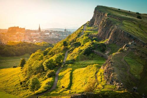 a view of a mountain with a city in the background at Garner Hotel Edinburgh - Haymarket by IHG in Edinburgh