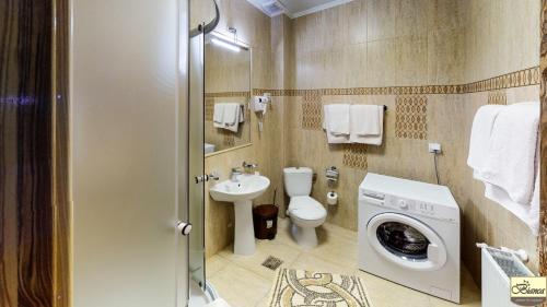 a bathroom with a toilet and a washing machine at Pensiunea Bianca in Botoşani