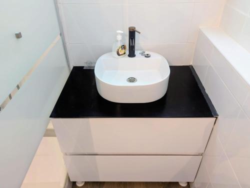 a bathroom with a white sink on a black counter at Maison de ville cosy Saumur avec Cour A 5 min à pied centre in Saumur