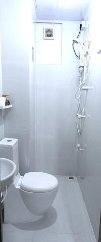 a white bathroom with a toilet and a shower at AlTyn Stay in Male City