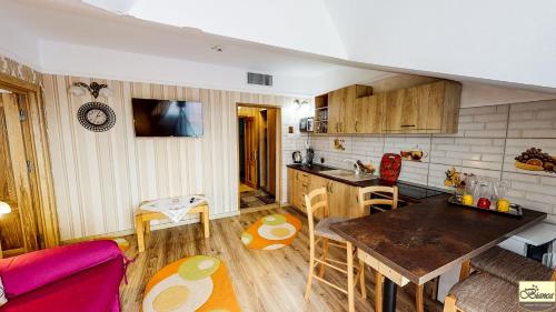 a kitchen and living room with a table and a couch at Pensiunea Bianca in Botoşani