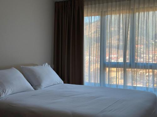 a bed in a bedroom with a large window at El Balcón de Potes in Potes