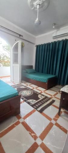 a bedroom with two beds and a tiled floor at Villa Rose-Luxor in Luxor