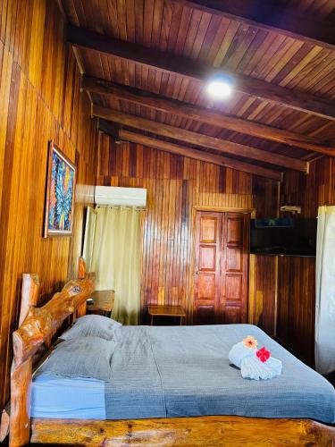a bedroom with a large bed with wooden walls at Hotel La Isla Inn in Puerto Viejo