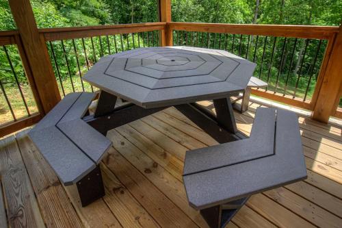 a picnic table and two chairs on a deck at Hilltop Haven By Avada Properties in Boyds Creek