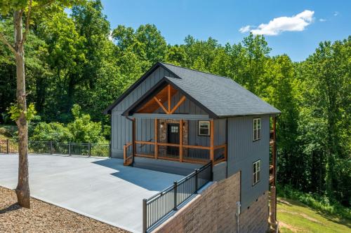 a tiny house with a courtyard and a deck at Hilltop Haven By Avada Properties in Boyds Creek