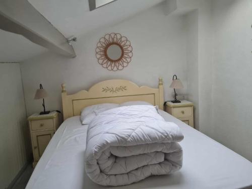 Una cama blanca con un edredón blanco y dos mesitas de noche. en Charmante maisonnette 4-5 pers à La Palmyre, en Les Mathes