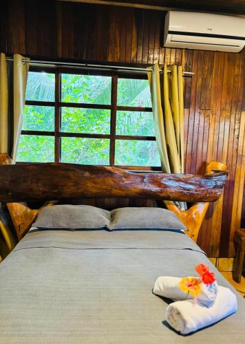 a bedroom with a bed with two pillows and a window at Hotel La Isla Inn in Puerto Viejo