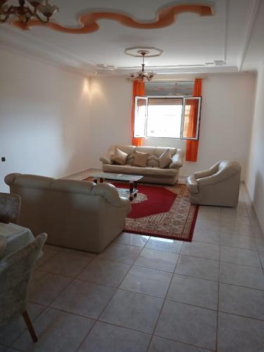 a living room with two couches and a rug at Karyat arkman nador in Nador