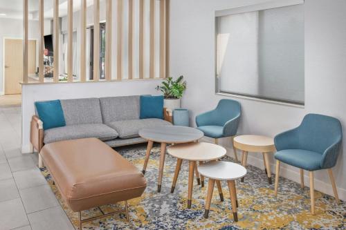 a waiting room with a couch and two chairs and a table at TownePlace Suites Detroit Warren in Warren