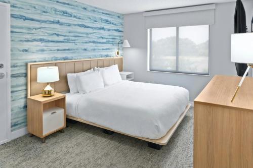 a hotel room with a bed and a window at TownePlace Suites Detroit Warren in Warren