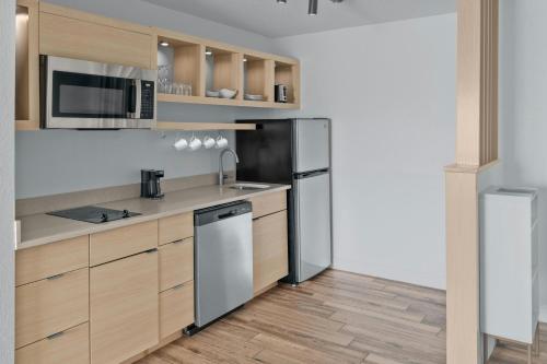 a kitchen with wooden cabinets and stainless steel appliances at TownePlace Suites Detroit Warren in Warren