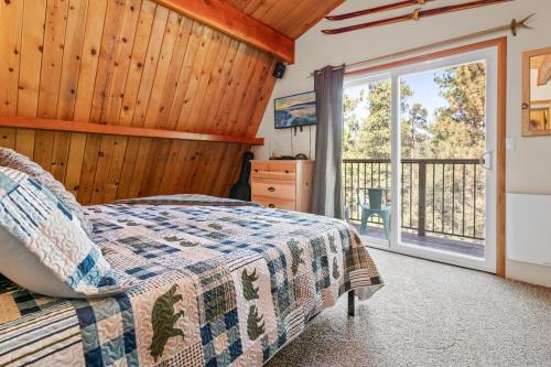 a bedroom with a bed and a large window at Big Bear Cabin with Treetop Views 3 Decks Arcade Game, Fireplace, BBQ, WIFI in Big Bear City