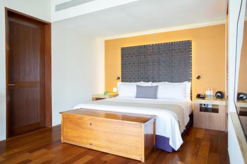 a bedroom with a large bed with a wooden dresser at Camino Real Monterrey in Monterrey