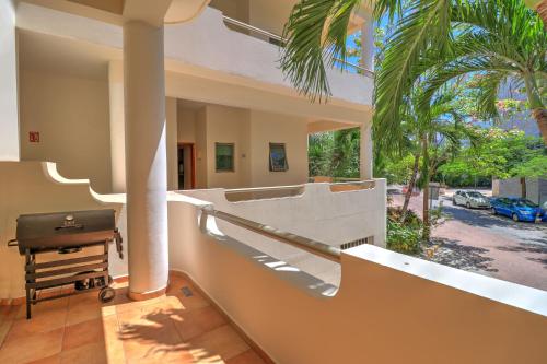 a house with a balcony with a grill and palm trees at Palmar del Sol by Riviera Maya Suites in Playa del Carmen