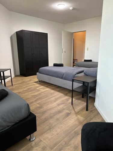 a room with two beds and a table in it at Airport Apartments Rüsselsheim in Rüsselsheim