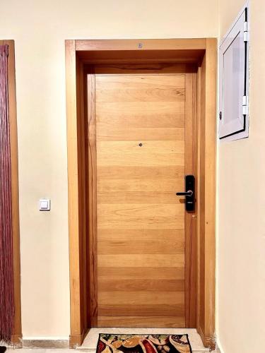 a wooden door in a hallway with a rug at Beautiful apartment with pool and sea horizon view in Fnidek