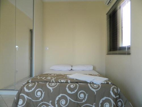 a bedroom with a bed with a mirror at Áries Apart Hotel in Bauru