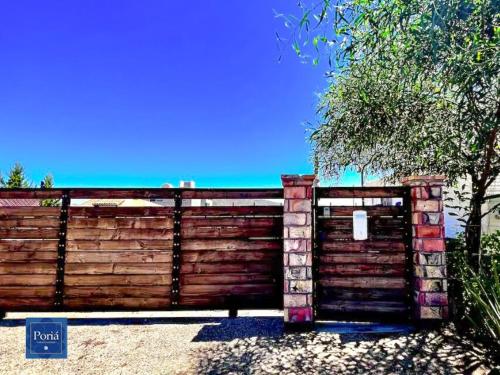 a wooden fence with a gate in a yard at Casa Poriá - Guadalupe Valley in Valle de Guadalupe