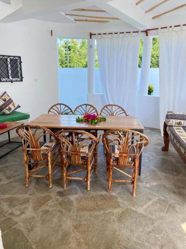 a dining room with a wooden table and chairs at Banana House in Watamu