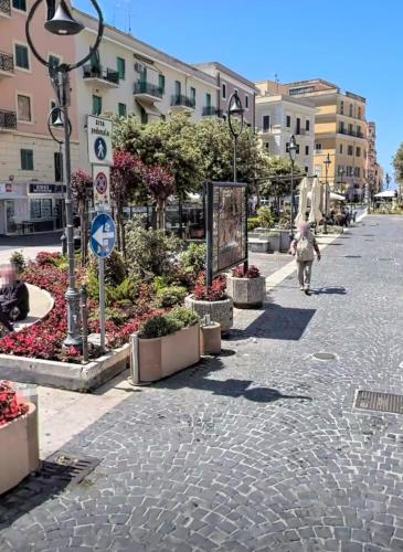 a woman walking down a street in a city at Tower casa vacanze in Anzio