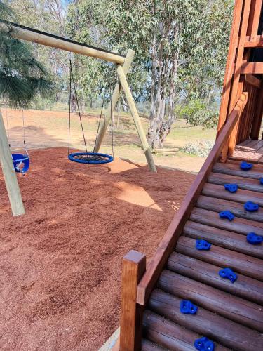 a playground with a swing set in a park at Palmers Lane Estate Hunter Valley in Pokolbin