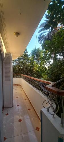 a balcony of a building with a table and bench at Villa Rose-Luxor in Luxor
