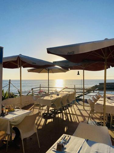 a group of tables and umbrellas on a beach at BEACH Arguineguin FIRST LINE 8 studio CHG FAMILY HOTEL in Arguineguín