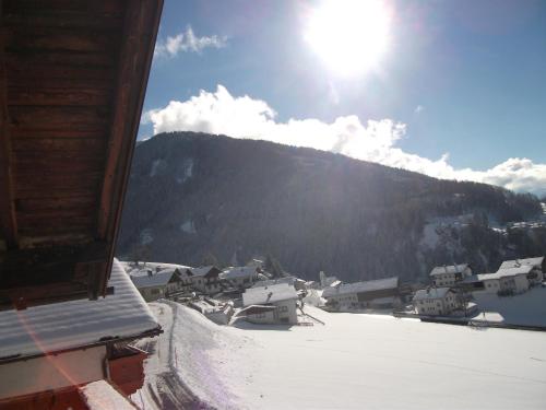 a view of a village in the snow with the sun at Ferienwohnung 2 Ferienhaus Gassner In Navis in Navis