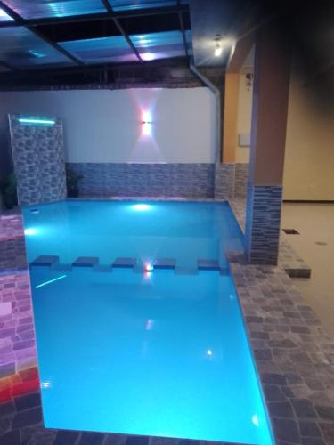 a large swimming pool with blue lights in a room at Gran Hotel Virrey in San Ramón