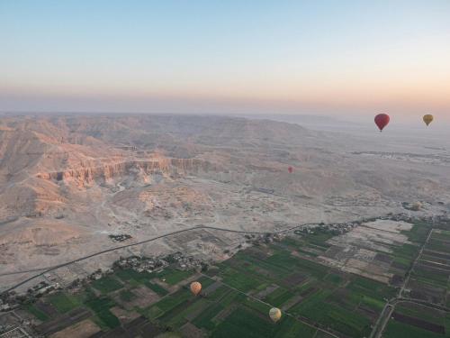 two hot air balloons flying over the grand canyon at Bab Al Shams Palace in Luxor