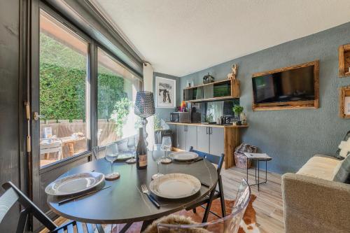 a dining room with a table and a tv at Chalet studio Megève enface des remontées mécaniques et parking gratuit in Demi-Quartier