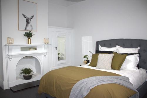 ein Schlafzimmer mit einem Bett und einem Kamin in der Unterkunft Elsie Cottage in Devonport