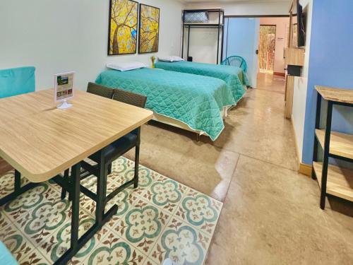 a room with two beds and a table in it at Hotel Fazenda Vale Alvorada in Cascavel