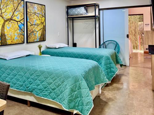 two beds sitting next to each other in a room at Hotel Fazenda Vale Alvorada in Cascavel