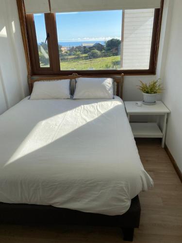 ein Bett in einem Zimmer mit einem großen Fenster in der Unterkunft Your refuge in El Yeco- Algarrobo in Algarrobo