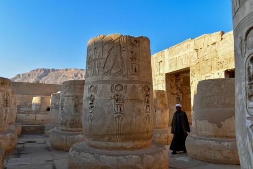a man walks through an ancient ruins at Bab Al Shams Palace in Luxor