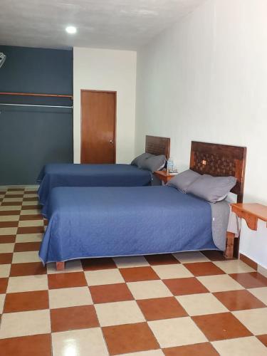 a bedroom with two beds and a checkered floor at Casa Camino Real, Habitación 1, Baño privado, Cafetera Escritorio in Ciudad Valles