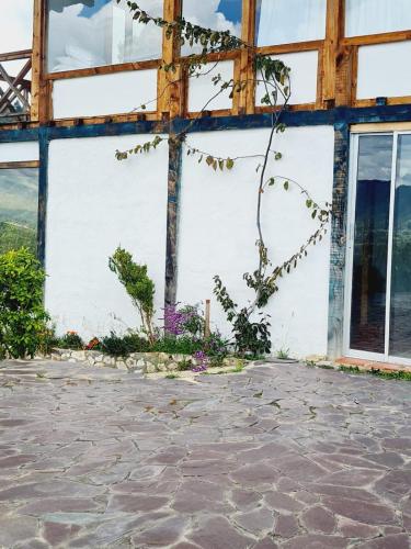 a building with windows and a stone patio at Chalet Montaña Tenjo Mirador in Tenjo